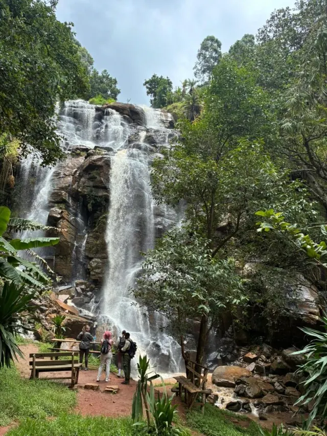 Guests standing at the foot of Mkuzi waterfall as it tumbles down mossy rock near Mullers