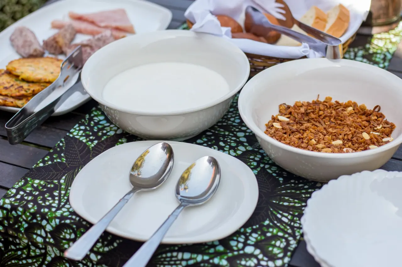 The breakfast spread at Mullers — yogurt, granola, cured meats, and rosti on a patterned kitenge cloth